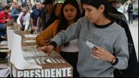 mulher deposita voto na urna no México